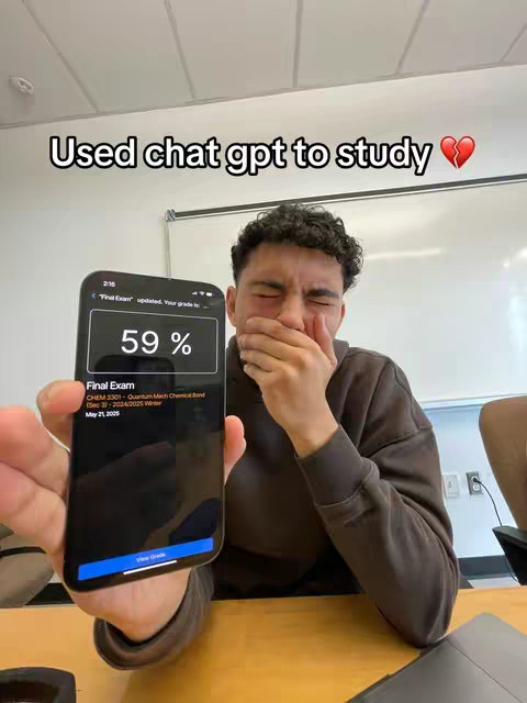 A young man is holding up a smartphone. The phone screen shows a low exam score and the man has his hand covering his mouth, and his eyes are closed, as if shocked or upset. The background is a classroom or office setting.