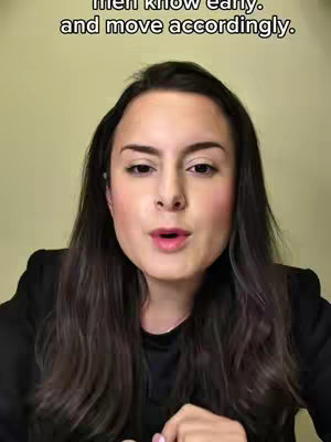 A woman with long, dark hair wearing a black top is centered in the frame, looking towards the camera with a slight smile and open mouth as if speaking. Above her head, white text overlays read, 'men know early. and move accordingly.' The background is a solid, nondescript brownish-yellow.