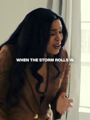 A woman with long, dark hair is the focal point. She wears a brown outfit and appears to be emotional, with her mouth slightly open. The text overlay reads: "WHEN THE STORM ROLLS IN."