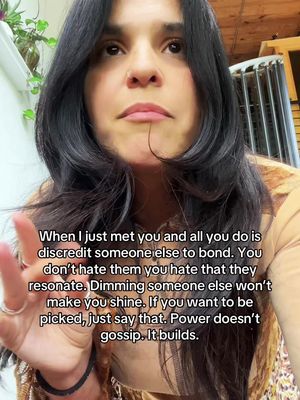 A woman with long dark hair and a neutral expression is the central focus, with a soft, slightly out-of-focus background. She's wearing a patterned top and accessories. Text overlaid describes astrological insights.