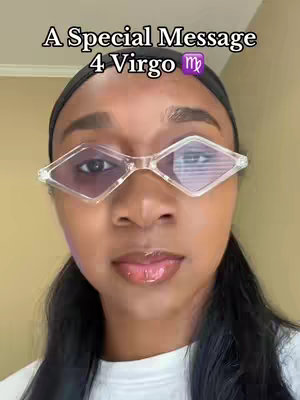 A selfie shows a person with dark hair pulled back, diamond-shaped glasses, and a white garment in front of a neutral beige background. Text overlay at the top reads 'A Special Message 4 Virgo' with a Virgo zodiac symbol.