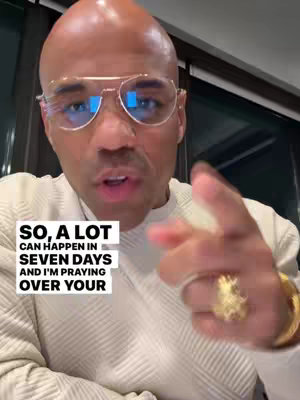 A close-up shot of a man wearing glasses, a white shirt, and a ring, pointing with his right index finger towards the viewer with a text overlay.