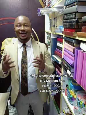 A man in a light-colored blazer is standing in front of shelves filled with books. Text overlayed on the image provides information about a bible and its price.