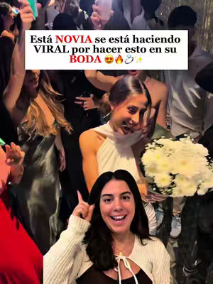 The cover image captures a lively wedding scene. In the foreground, a woman with dark hair and a white top smiles directly at the camera, pointing upwards. Behind her, another woman in a sleeveless white dress and a bunch of white flowers seems to be enjoying the celebration. The background is filled with people also celebrating creating an atmosphere of fun and festivity.