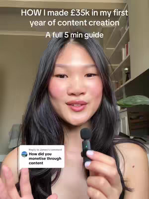 A woman with long black hair, wearing a black top, holds a small microphone and is the central focus. The background has a bookshelf with various objects and some blurred elements. Overlayed text announces the video's topic about creating content and making money from it.