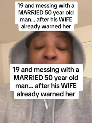 The image is a selfie-style video cover showing the creator front and center, with text overlays. The creator, appearing to be in their twenties, wears a gray hoodie. Two text overlays are shown, one above and one below the creator's face, repeating the same statement, which uses bold clear fonts against a white background, adding a conversational tone, hinting at a complex situation involving a married man and a younger woman. The composition is simple and focused, drawing attention to the message in the overlays.