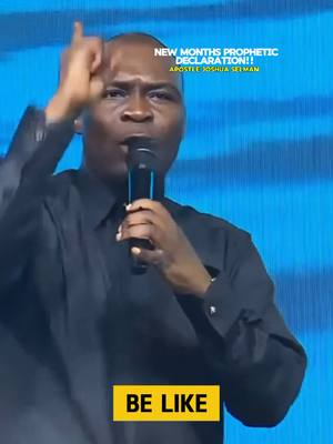 The cover image features Apostle Joshua Selman speaking into a microphone, with his right index finger raised and pointing upwards. Text overlays read "NEW MONTHS PROPHETIC DECLARATION!! Apostle Joshua Selman" in white, centered text at the top, and "BE LIKE" in a yellow rectangle at the bottom. The background consists of vertical blue lines.