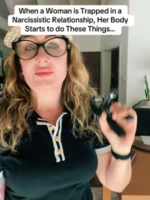The image is a medium shot featuring a woman with curly blonde hair, wearing black-rimmed glasses and a black top with a white-trimmed collar. She is holding a black object in her right hand, her expression is neutral. The background is slightly blurred, showing what appears to be a hallway in a home. The text overlay positioned above the woman's head provides context about the topic of the video.