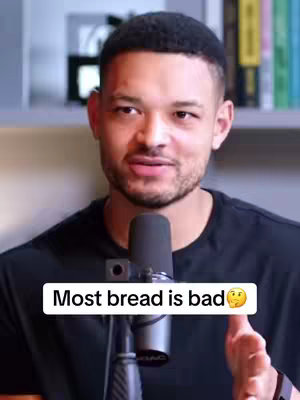 A man with short black hair and a trimmed beard is positioned in front of a microphone, appearing to be in a studio setting. A white text overlay that reads, "Most bread is bad 🤔" is superimposed across the bottom of the image, with a questioning face emoji next to the last word.