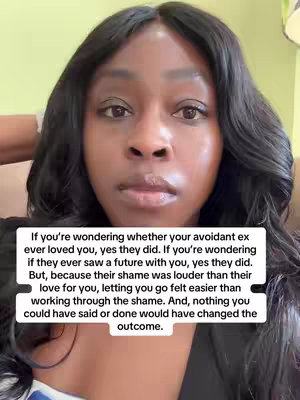 A close-up shot of a Black woman with long, dark hair, looking directly at the camera with a neutral expression. A white text overlay containing a message about breakups and attachment styles is positioned over her face. The background is slightly blurred, with hints of a light green and beige.