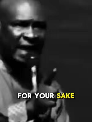 A black and white image captures a man speaking into a microphone. The man's head and shoulders are visible, and the bottom of the image has a text overlay in white with a yellow highlight.