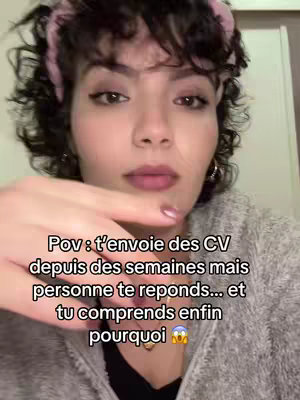 A selfie-style video cover image featuring a young woman with curly hair and a pink headband. Overlaid on her face is text describing a relatable job-seeking experience.
