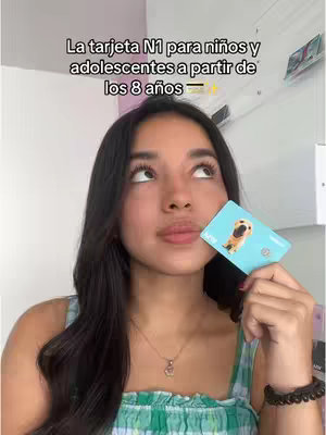 A young woman with long black hair is holding up a teal credit card with an dog illustration, looking upwards in what appears to be her home. Text overlays at the top in white.