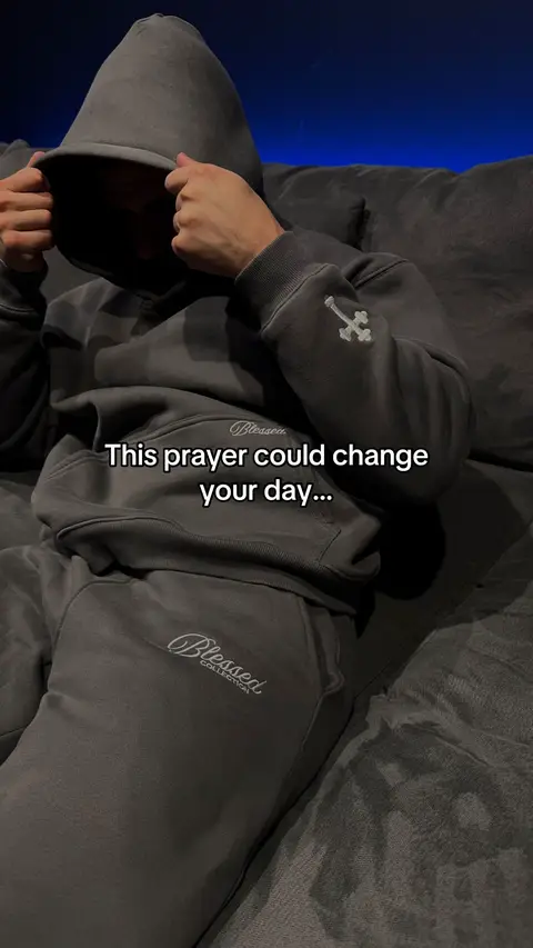 A person in a gray hoodie and sweatpants is seated on a gray couch with a dark blue background. The person has their hood up, obscuring their face. The hook text is overlayed on the bottom half of the image. The photo uses a neutral color palette, focusing on shades of gray with a deep blue background.