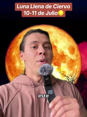 A man with light brown hair and a pink hoodie is holding a microphone in front of a large orange moon. There is overlay text in the upper center and at the bottom of the image.