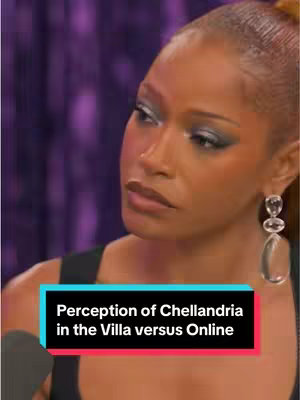 A close-up shows a woman with styled hair looking at the camera with a serious expression. She wears a black top with a rectangular graphic that has multi-colored text at the bottom.