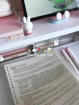 A top down view of a study desk. There is a notebook with notes, a tablet propped up and there is a decorative bunny and pens. The phrase 'cleaning your fyp' is overlaid on the image.