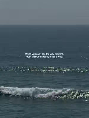 A serene image of the ocean under a slightly overcast sky. The water is a deep blue, with gentle waves visible. Text is overlaid on the water, offering an inspirational quote.