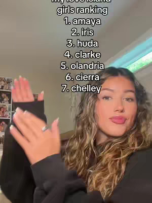 A young woman stands in front of a blurred background next to a window. She is looking at the camera. Text overlay is shown over the background, featuring a list of names ranking girls.
