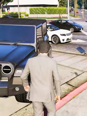 A man in a grey suit stands with his back to the camera, facing the street. To his left is a black jeep. In the background are a white car and a black car stopped at a traffic light. The scene takes place on a sunny day, with the building in the background contributing to a sense of urban setting.