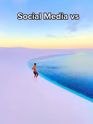 The cover image depicts a man standing in a desert-like landscape next to a body of water. The text overlay "Social Media vs" is placed at the top. The scene is bathed in a gradient of colors - turquoise and blues of the water contrasted by the soft, white sand, all under a backdrop of a light blue sky with a yellow-orange horizon. The composition is simple, focusing on the man against the backdrop of the water and landscape.