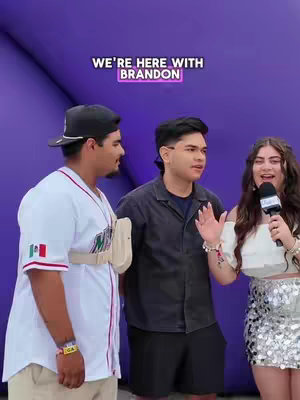 Three people are standing in front of a purple background. The person on the right, a woman with long brown hair, is holding a microphone and speaking. The three are smiling, suggesting a positive interaction. The text overlay indicates that the video will be about someone named Brandon. The overall layout is a vertical composition with a focus on the people.