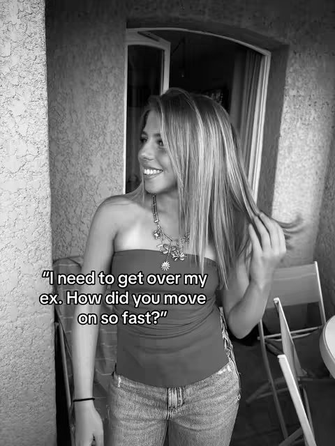 A black and white image of a young woman stands outside in front of a stone wall, looking off to her left with a slight smile. She is wearing a strapless top and jeans, and is holding her hair. Text is overlaid in the image.