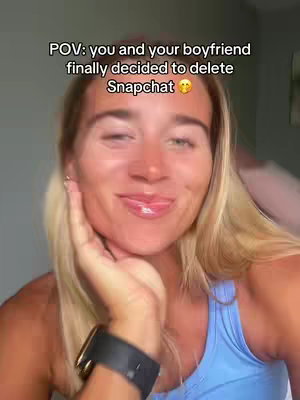 A woman with blonde hair and a blue tank top smiles at the camera, resting her hand on her cheek. Text overlay says 'POV: you and your boyfriend finally decided to delete Snapchat'.