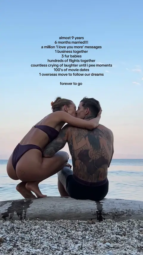 A couple is embracing and kissing on a beach, the woman is turned towards the camera, and the man has multiple tattoos. The text is in light gray sans-serif font with a dark blue gradient background.