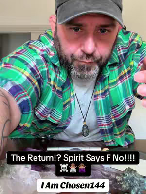 A selfie-style shot with a man wearing a gray cap and a green plaid shirt. The foreground displays a bearded man looking at the camera through a low-angle shot, and he's holding something out of the frame. In the background are some decorations on a table and a window.