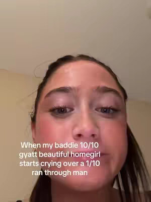 A close-up shot of a young woman's face, angled slightly upwards. She appears to be crying, with a slightly flushed complexion and shiny skin. A text overlay is positioned near the bottom, detailing a humorous scenario. The background is a plain, light-colored surface, implying this is a selfie-style video.