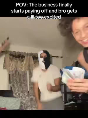 The cover image shows a room with a person wearing a black and white ski mask that is dancing excitedly. A person on the right is showing money to the camera. The background is of a curtain and a bed.