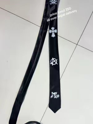 A black tie with white graphics. A skull and crossbones, a cross-like design, and the anarchy symbol are printed on the tie. The words "Punks are Dead" are also visible. Some text is on the image as well, including price and delivery information and the tie is set against a light-colored tiled surface.
