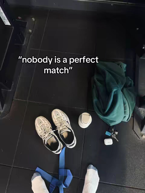 An overhead shot shows gym shoes, a water bottle, and a jacket on a black gym floor. The text overlay says, "nobody is a perfect match."