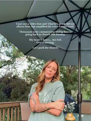 A woman with long blonde hair stands outdoors, framed from the chest up. She's wearing a green t-shirt, arms crossed, with a serious expression, set against a blurred background of foliage and partial view of a patio with an umbrella overhead. Text is overlaid on the top of the image.