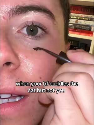 Close-up of a person's face, with focus on the eye. They are applying eyeliner with a brush, with the eye being the main focus. Light skin, with a tear coming down.