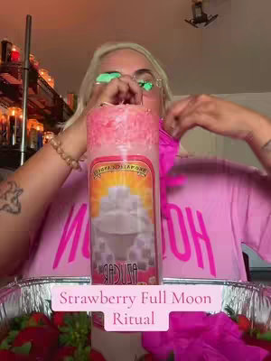 The cover image shows a woman holding a large pink candle, with text overlayed and various items in the foreground. The woman is blonde and wears glasses. The candle is the central focus, surrounded by what appears to be strawberries. The scene has a warm, indoor lighting.