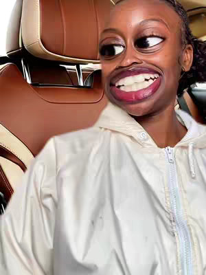 The cover image features a person in a car, with a digitally altered face featuring exaggerated features. The person is wearing a white jacket and the background includes a car seat. The face is heavily edited, with oversized eyes and mouth.