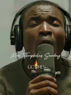 The cover image features a close-up of a man wearing headphones and singing into a microphone, possibly in a recording studio. Text overlays identify him as "Min Theophilus Sunday." The composition is dominated by the face of the man with closed eyes, focusing on performance. The text element "GOSHEN" and a flame like graphic are at the bottom of the image. The color palette is slightly desaturated, with a focus on neutral tones.