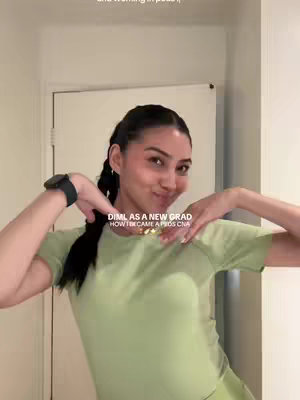 A woman in light green scrubs poses with her arms up near her head, and text overlays in the center of the image.
