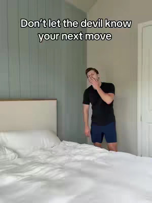 The cover image shows a man standing in a bedroom. He is wearing a black t-shirt and dark blue shorts. He is holding his hand up to his mouth as if he is covering a yawn or a cough. A bed with white bedding is in the foreground. The text is in black and is located in the top left corner of the image.