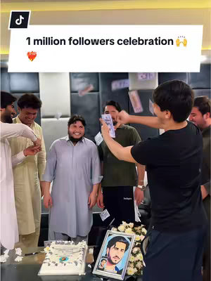 A group of men are celebrating, a person throws money toward other people as a cake is on the table, with a framed portrait
