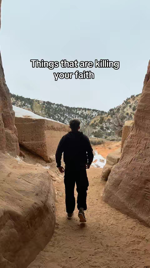 A man walks away from the camera along a path carved into rock formations. The path leads towards a snowy mountain landscape. Text overlayed on the image.