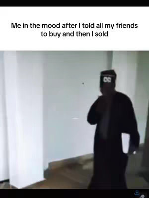 The image captures a moment from a video, featuring a person walking away in a room. The person is dressed in dark clothing, possibly a robe, with what appears to be eyes drawn on the headwear. The setting consists of white walls and what may be a wooden floor. Text at the top of the image reads, 'Me in the mood after I told all my friends to buy and then I sold'.