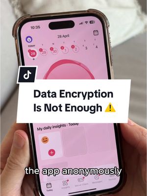 A person is holding a smartphone displaying a period tracking app. The app interface shows a pink-themed calendar with encircled dates, and a section for daily insights. A text overlay says "Data Encryption Is Not Enough !" over the app screen. The phone is in a protective case, held against a background of a light-colored surface.