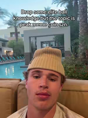 A young man with a beanie and a neutral expression is centered in a selfie-style shot. He is sitting outdoors, with a swimming pool and palm trees visible in the background.