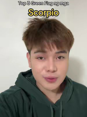 A young man with brown hair wearing a dark green hoodie is centered in the frame. Above him is a yellow rectangular banner with the phrase "Top 3 Green Flag ng mga Scorpio" in black text. The background is a plain white wall.