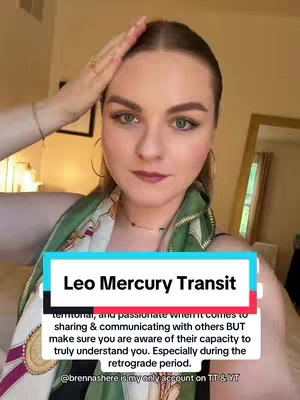 A woman with fair skin and reddish-blonde hair is positioned at the center, looking directly at the camera. She is dressed in chic attire with a patterned scarf and jewelry. The video has a well-lit, bright environment. A text overlay provides additional context adding to the vertical video composition.