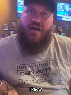 A man with a beard and a Carhartt shirt looks directly at the camera with a surprised expression. The text "I know" is overlaid at the bottom.