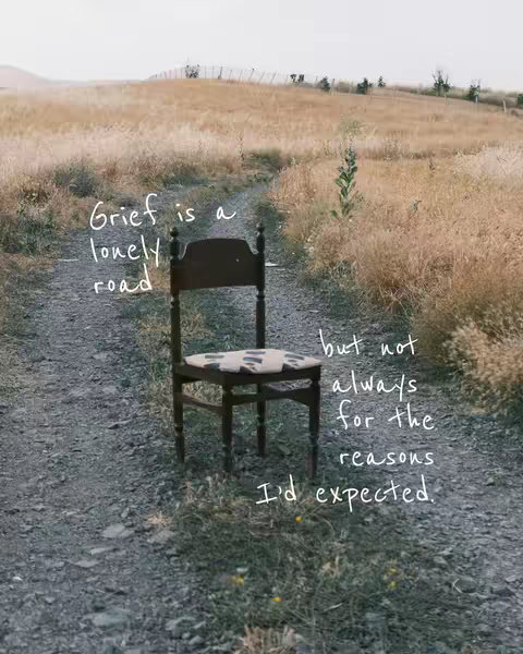 An image taken outdoors, likely in a field. A weathered wooden chair faces the viewer, placed on a stone path that leads into the distance. The path is flanked by tall, dry grass under a slightly overcast sky. Text is overlaid in handwritten style on the image, describing the emotional and physical impact of grief.